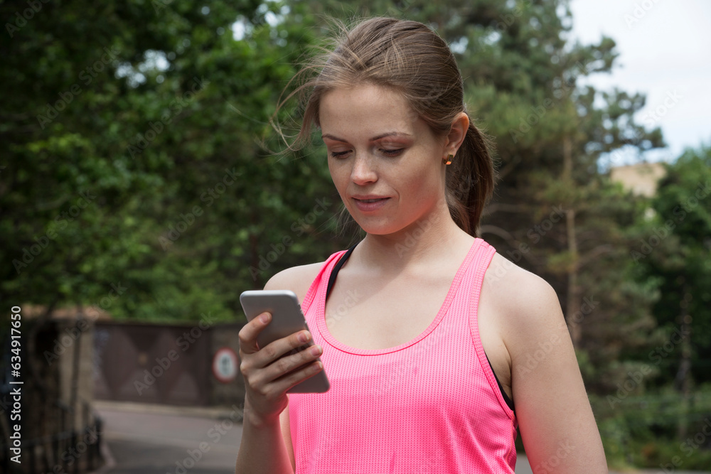 Sporty woman looking at Smartphone after training.