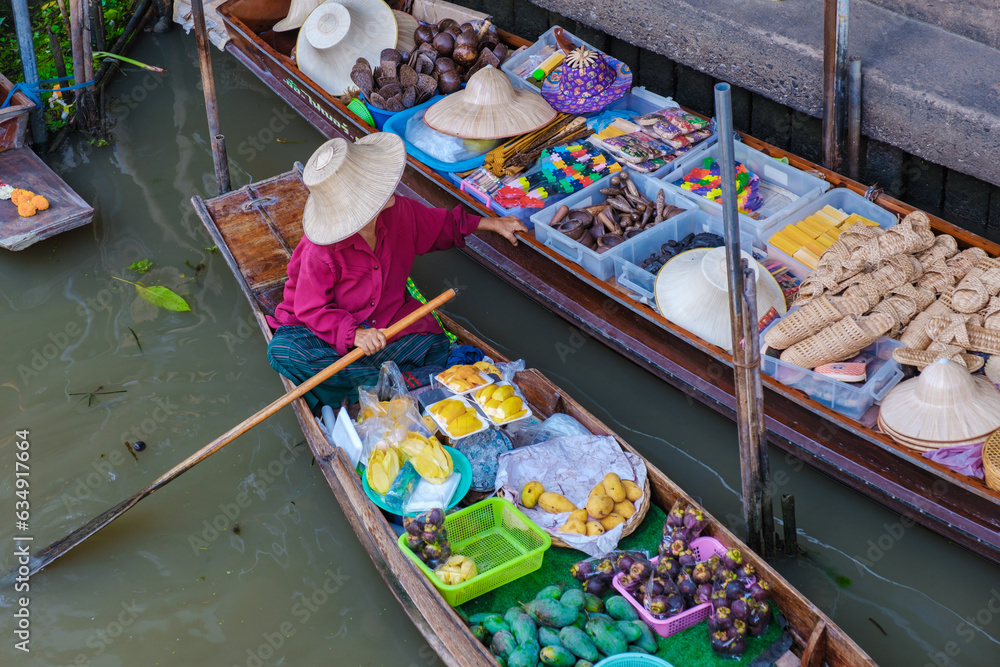 Fototapeta premium market stall holders in small boats selling local fruits and vegetables, Damnoen Saduak Floating Market, Thailand