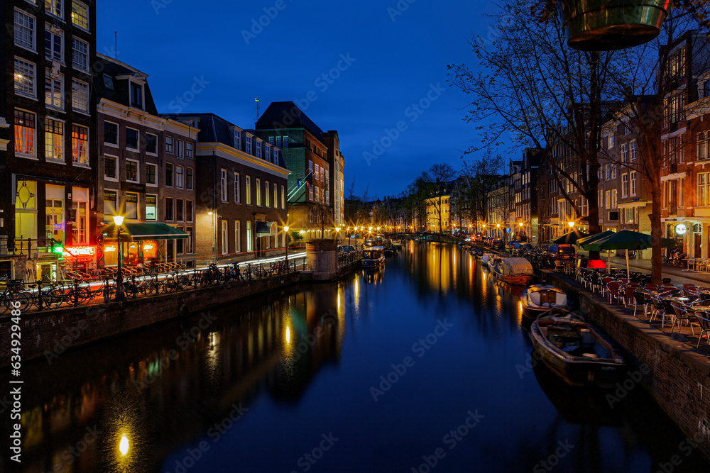 View of the Amsterdam canals and embankments along them at night.
