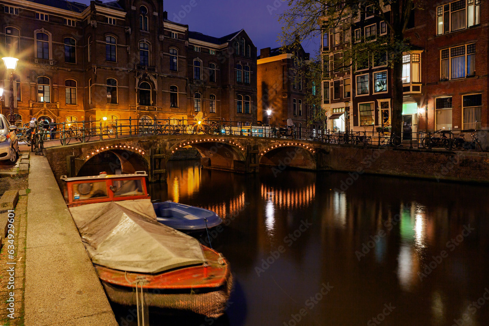 View of the Amsterdam canals and embankments along them at night.