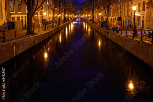 View of the Amsterdam canals and embankments along them at night.
