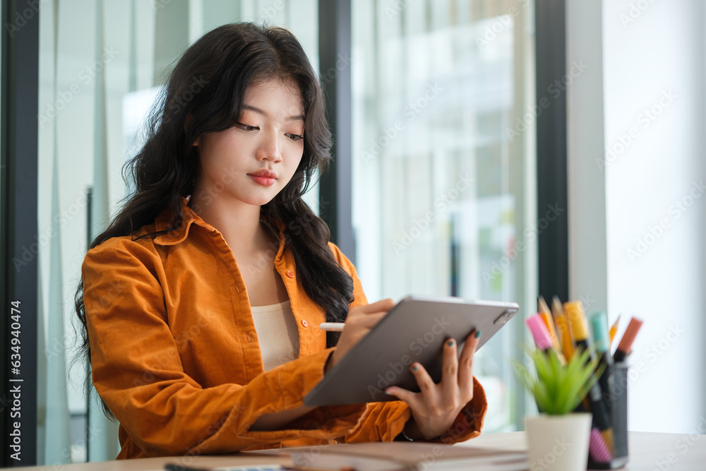 Creative woman using digital tablet and working at modern office. Creative woman using digital tablet and working at modern office.