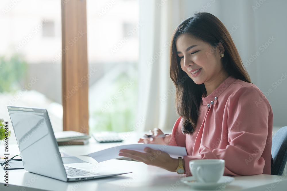 A young female administrative assistant making notes of working planning organizing information in her office. A young female administrative assistant making notes of working planning organizing information in her office.