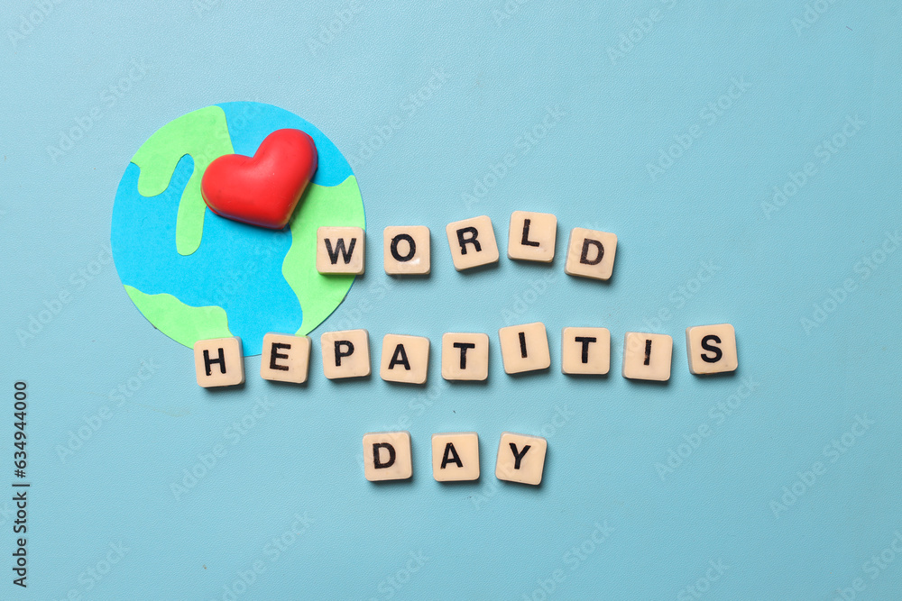 Fototapeta premium Top view of text WORLD HEPATITIS DAY on cubes and globe with a heart isolated on blue background