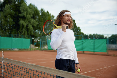 Happy smiling male tennis player ready for morning workout on outdoor court © Nomad_Soul