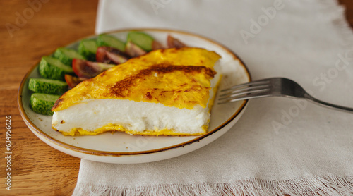 A healthy breakfast, omelet poulard with vegetables on a plate on a wooden dining table photo