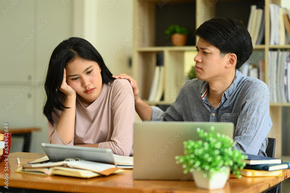 Caring male student consoling his female friend. Friendship, support and youth lifestyle concept Caring male student consoling his female friend. Friendship, support and youth lifestyle concept