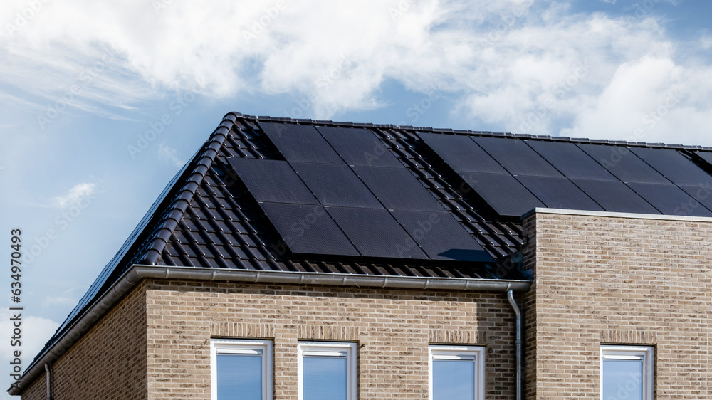 Newly build houses with solar panels attached on the roof, Photovoltaic panels on the roof. Roof Of Solar Panels. View of solar panels solar cell Newly build houses with solar panels attached on the roof, Photovoltaic panels on the roof. Roof Of Solar Panels. View of solar panels solar cell