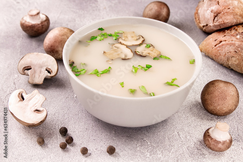 Homemade mushroom soup in a bowl on a gray background.