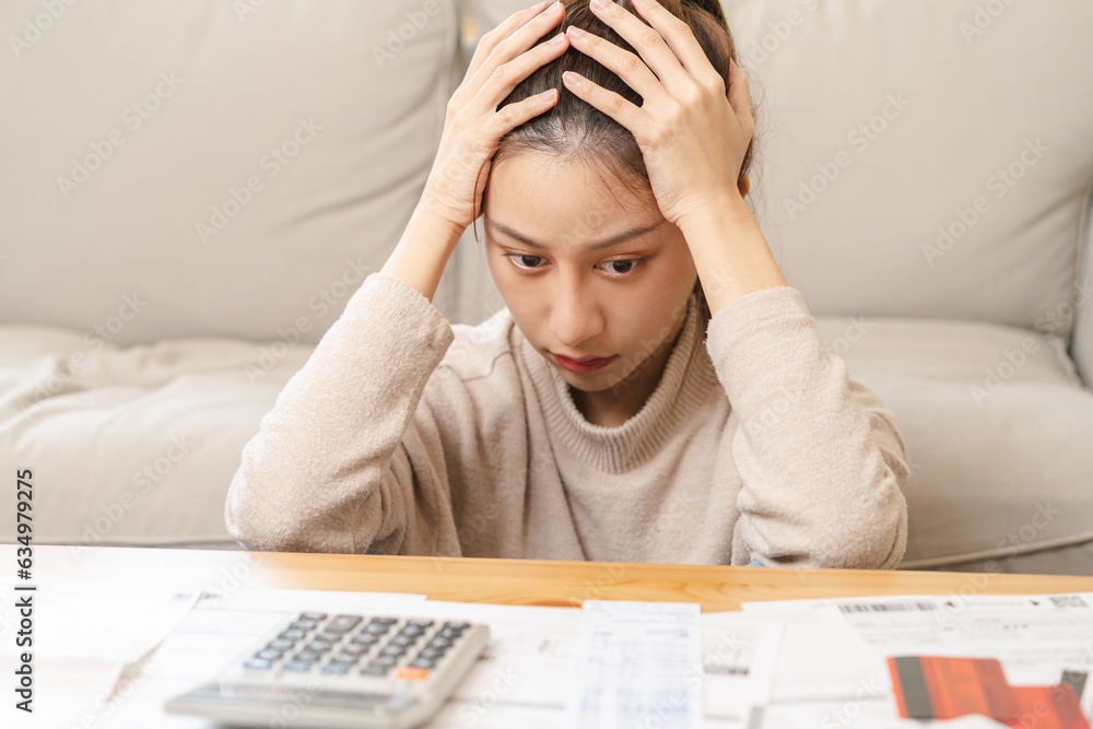 Financial owe asian young woman, girl sitting suffer, stressed and confused by calculate expense from invoice or bill, have no money to pay, mortgage or loan. Debt, bankruptcy or bankruptcy concept. Financial owe asian young woman, girl sitting suffer, stressed and confused by calculate expense from invoice or bill, have no money to pay, mortgage or loan. Debt, bankruptcy or bankruptcy concept.