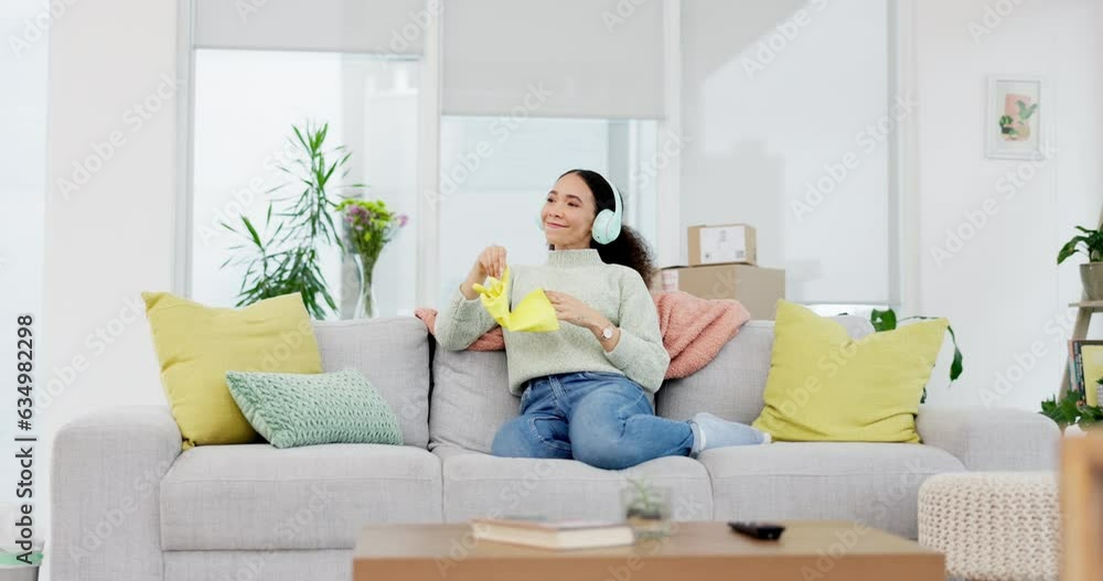 Music, headphones and woman on sofa after cleaning home, relax and taking gloves off. Housekeeping, break and female with earphones in living room for podcast, radio or audio after house spring clean Music, headphones and woman on sofa after cleaning home, relax and taking gloves off. Housekeeping, break and female with earphones in living room for podcast, radio or audio after house spring clean