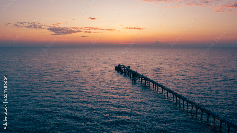 Fototapeta premium aerial drone view of oil jetty at morning sunrise over the sea in the east of Thailand.