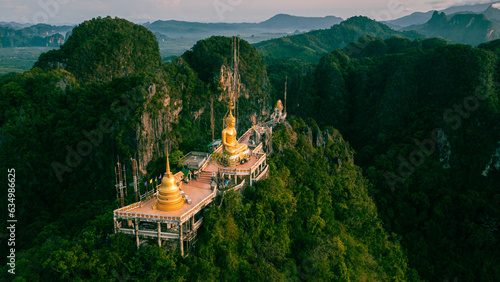 Beautiful aerial drone view of buddha statue on top of the mountain at sunrise, Wat Tham Sua (Seua) or (Tiger Cave Temple), Krabi, Thailand. photo
