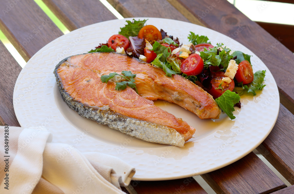 Fried salmon steak with salad