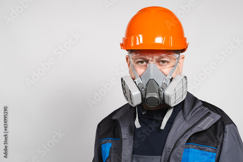 A man wearing a helmet, respirator and goggles on a white background photo