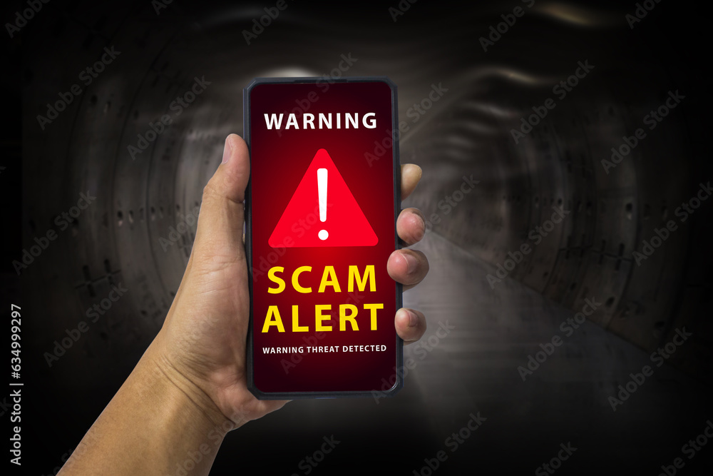 Man hand holding a mobile phone with red screen and warning icon with the text "SCAM ALERT", Security mobile concept, security risk. - obrazy, fototapety, plakaty 