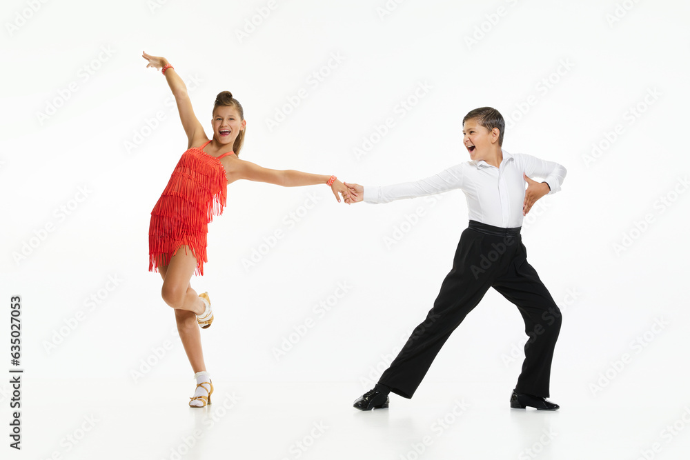 Boy and girl, children, friends making beautiful performance, dancing retro dance styles against white studio background. Concept of childhood, hobby, active lifestyle, performance, art, fashion Boy and girl, children, friends making beautiful performance, dancing retro dance styles against white studio background. Concept of childhood, hobby, active lifestyle, performance, art, fashion