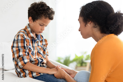 Supportive Mother Talking To Unhappy Little Boy Son Indoors