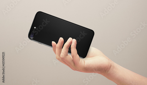 Adult hands giving a black mobile isolated on glay background.mobile phone care and service repair concept. photo