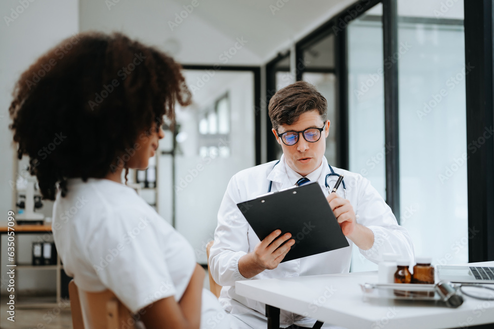 Doctor and patient discussing something while sitting at the table . Medicine and health care concept. Doctor and patient discussing something while sitting at the table . Medicine and health care concept.
