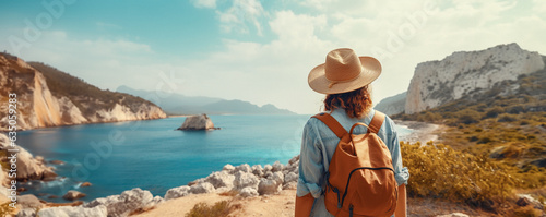A person wearing a straw hat and a backpack standing on a cliff overlooking a blue sea and small islands. The cliff is white rocksa. The sky is blue with clouds. The mood is peaceful and serene. 