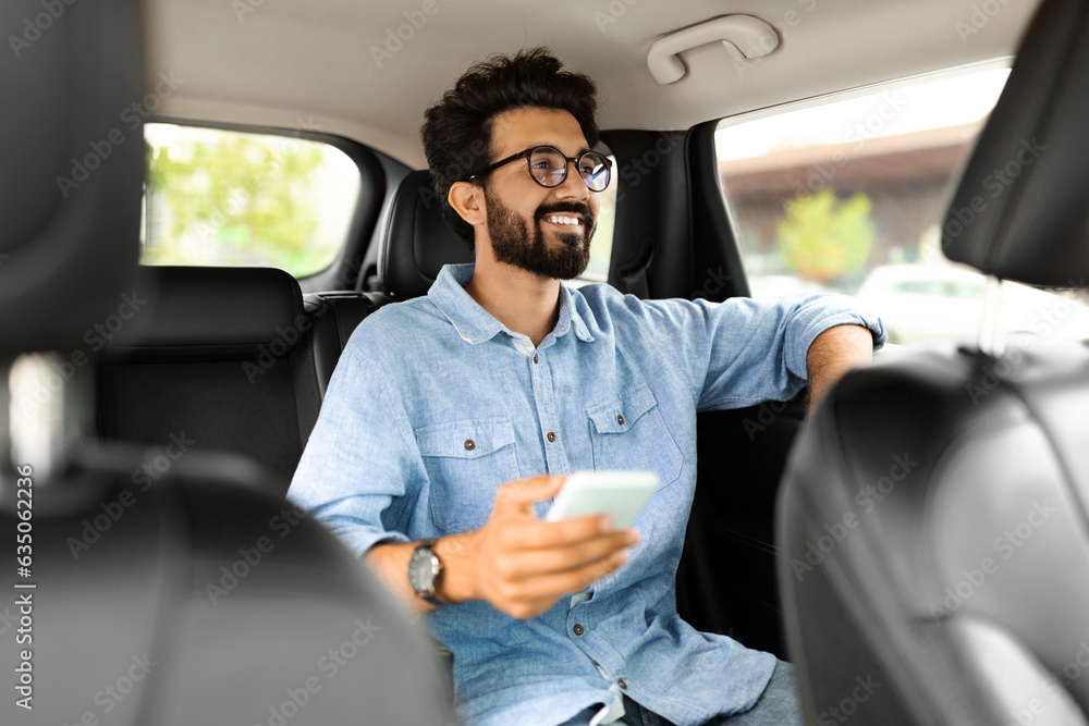 Ταπετσαρία Indian man sitting on car back seat, using cell phone
