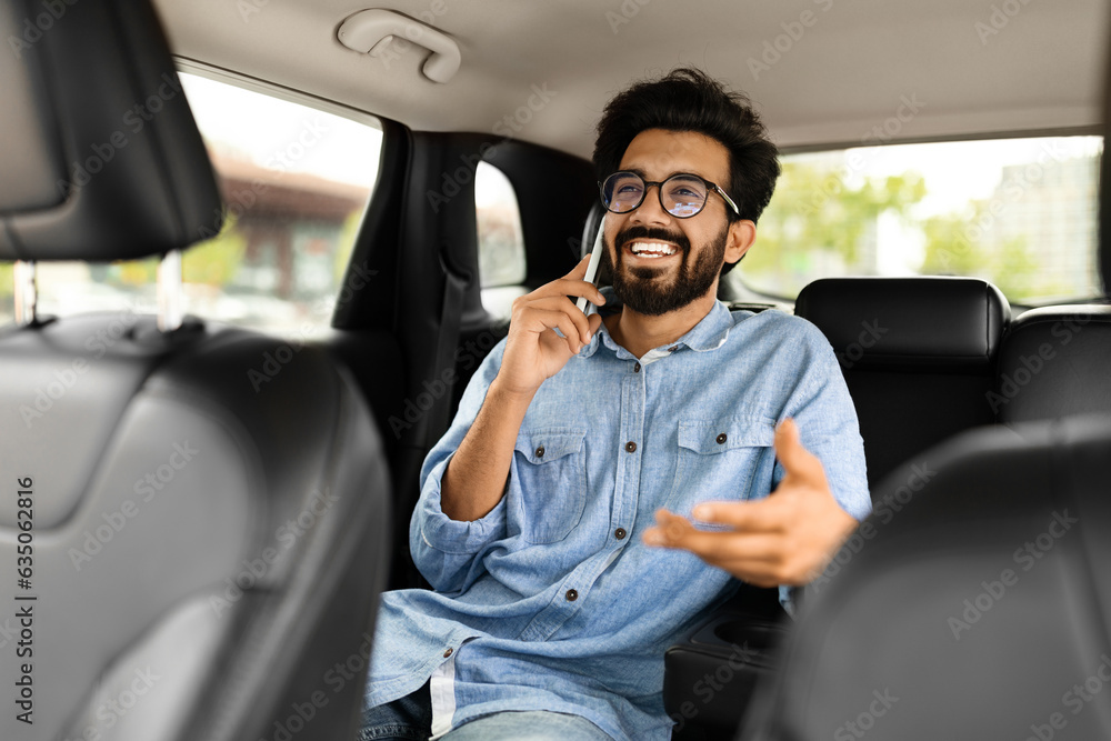 Eastern guy sitting on car back seat, talking on phone Eastern guy sitting on car back seat, talking on phone