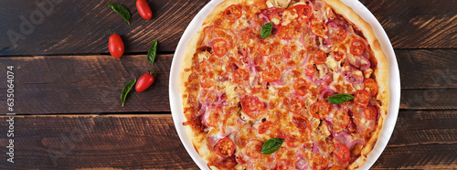 Italian pizza with ham, chicken, tomatoes and cheese. Top view, banner