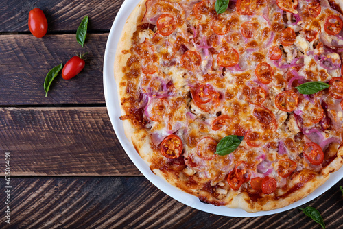Italian pizza with ham, chicken, tomatoes and cheese. Top view