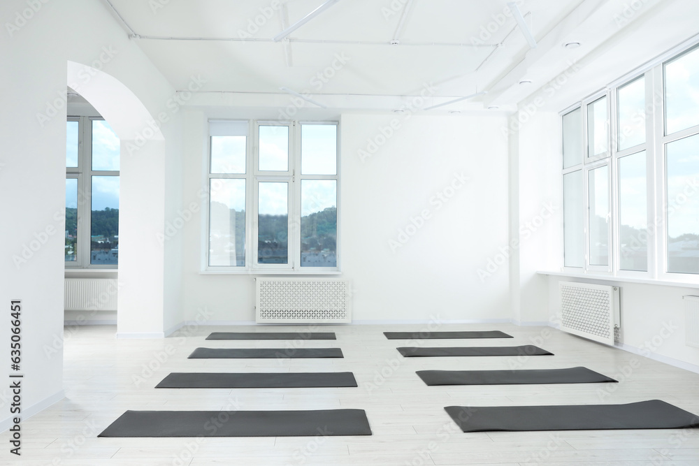Spacious yoga studio with exercise mats and big windows Spacious yoga studio with exercise mats and big windows
