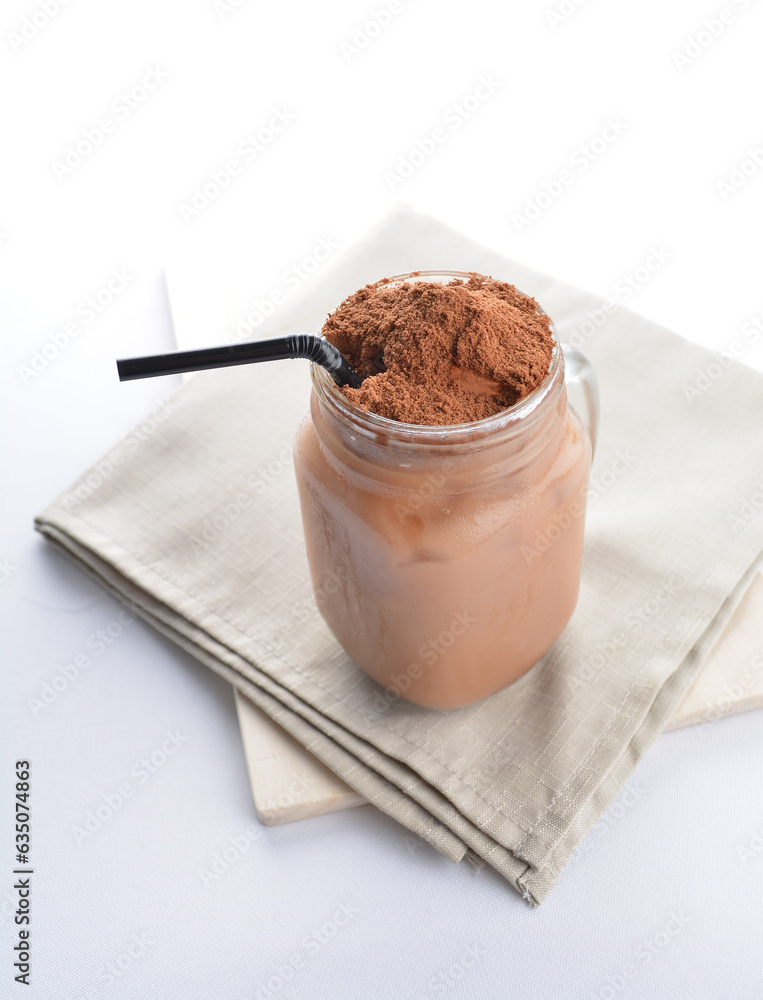 cold iced chocolate milk milo dinosaur with coco powder in glass black straw on grey cloth white background asian beverage halal food drink menu for hotel bar cold iced chocolate milk milo dinosaur with coco powder in glass black straw on grey cloth white background asian beverage halal food drink menu for hotel bar