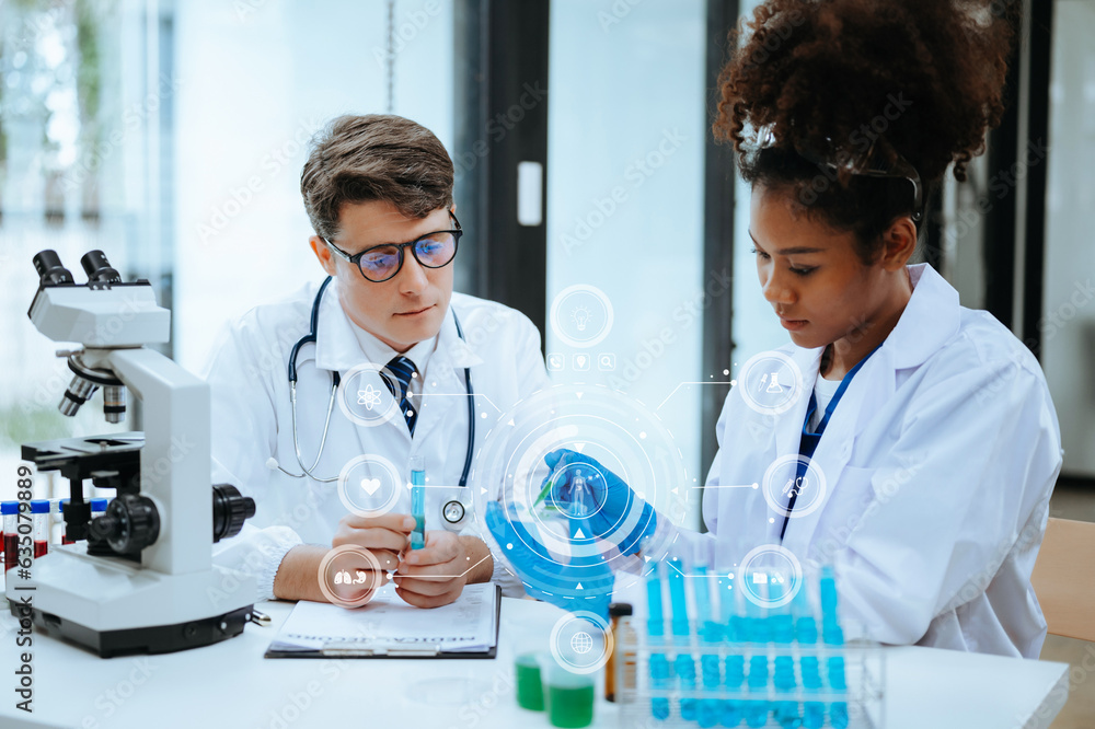 Focused mature male doctor and African female nurse look at tablet and laptop screen discuss anamnesis together. Concentrated diverse medical professionals Focused mature male doctor and African female nurse look at tablet and laptop screen discuss anamnesis together. Concentrated diverse medical professionals