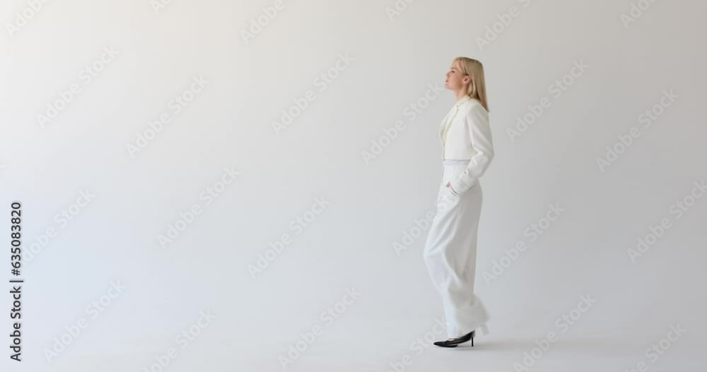 A stern and serious woman is seen on a clean white backdrop, walking with a determined expression. Her focused gaze and firm posture indicate her strong and resolute demeanor. A stern and serious woman is seen on a clean white backdrop, walking with a determined expression. Her focused gaze and firm posture indicate her strong and resolute demeanor.
