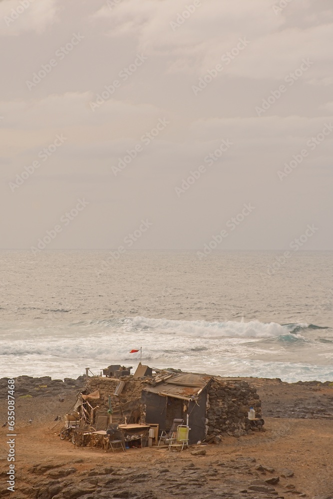 Obraz premium Lonely abandoned old house on the coast against sea in El Confital, Las Palmas de Gran Canaria, Spain