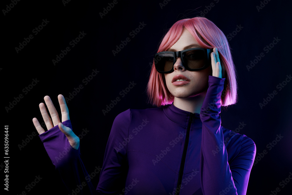 Beautiful woman in futuristic costume with flowing hair while touching air in neon lights. Augmented reality, game, future technology concept, VR, cinema. Beautiful woman in futuristic costume with flowing hair while touching air in neon lights. Augmented reality, game, future technology concept, VR, cinema.