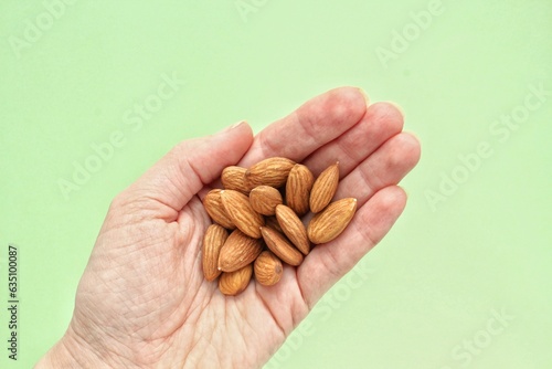 Woman holding organic almond nut in hands. Nutrition healthy food choice concept. Calories dieting snack. Sustainable lifestyle. Close-up