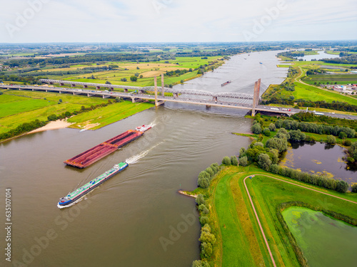 Obraz na płótnie Aerial View on Cargo Ships sailing on the Waal River in The Netherlands w salonie