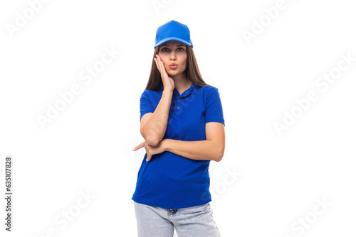 well-groomed young brunette woman promoter in a blue t-shirt and cap on a white background with copy space