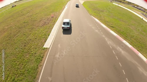 aerial filming of a circuit race on an asphalt circuit, fpv drone, racing cars go fast, time trials, sharp turns