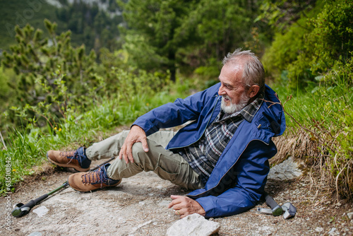 Photography Senior man injured his leg during hike in the mountains.