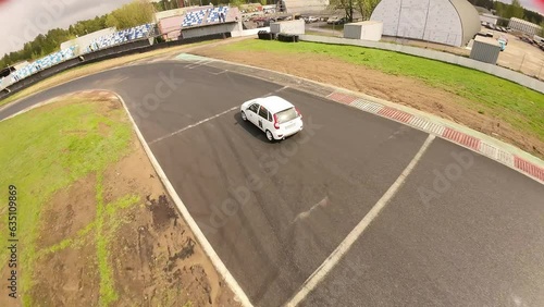 aerial filming of a circuit race on an asphalt circuit, fpv drone, racing cars go fast, time trials, sharp turns