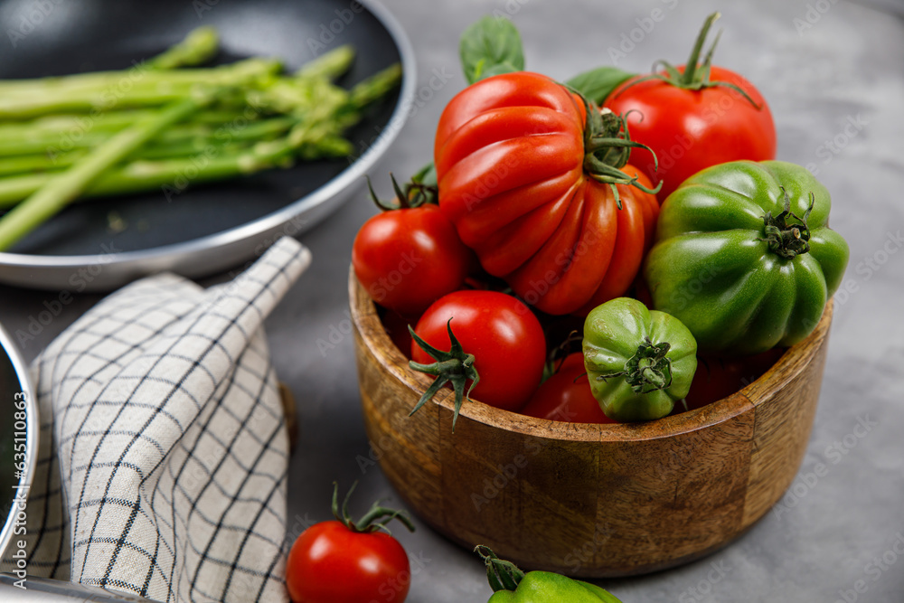 Red and green tomatoes in a basket on a damp background Red and green tomatoes in a basket on a damp background