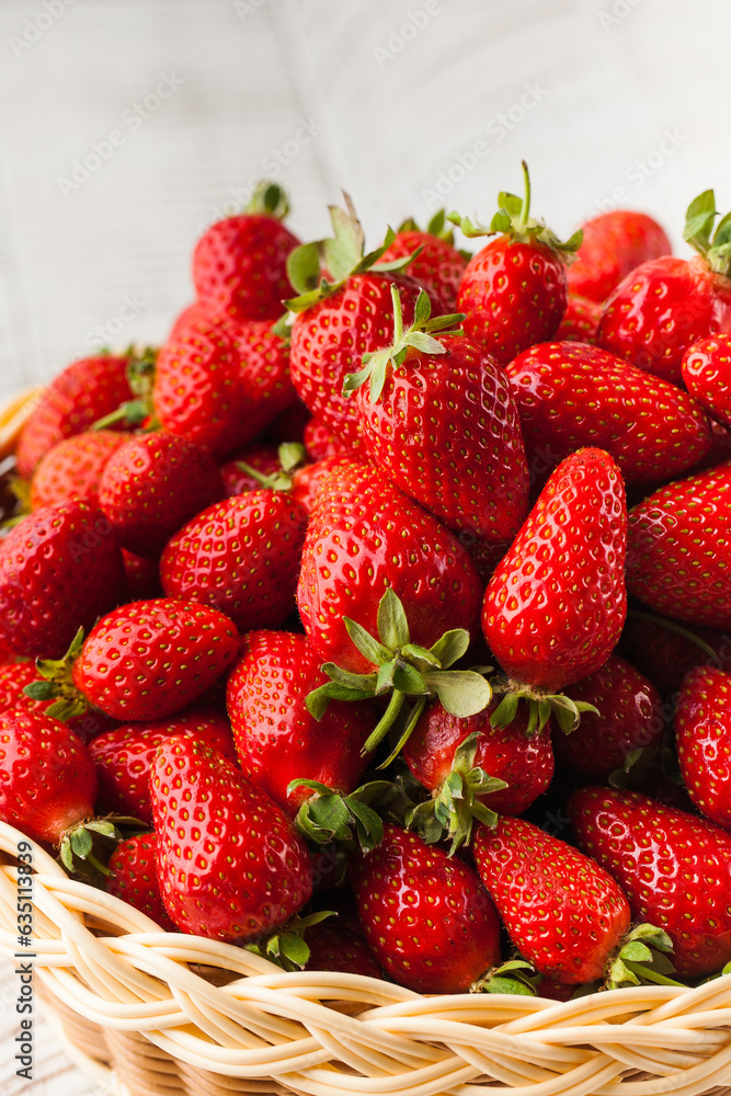 A basket with ripe juicy strawberries on a wooden table. Berries, harvesting. A basket with ripe juicy strawberries on a wooden table. Berries, harvesting.