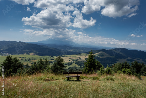 Empty wooden bench at the top of Wysoki Wierch, with a view to Pieniny Mountains, Poland. 