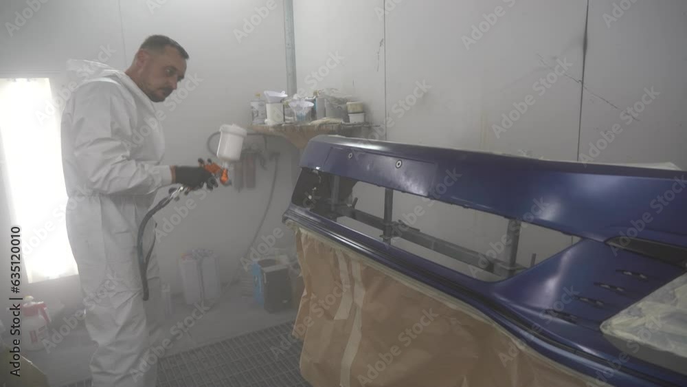 Kyiv, Ukraine - August 12, 2023: Paint shop at the car service station. The master of the paint shop paints the car. Painting a car in a paint booth Kyiv, Ukraine - August 12, 2023: Paint shop at the car service station. The master of the paint shop paints the car. Painting a car in a paint booth
