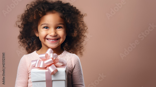 Happy smiling girl holding gift box on a colored background © MP Studio