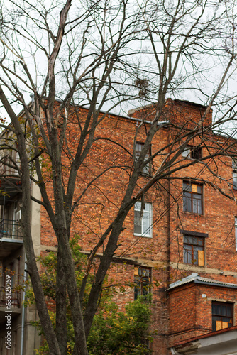 Old brick building behind the trees in the city center of Kharkiv