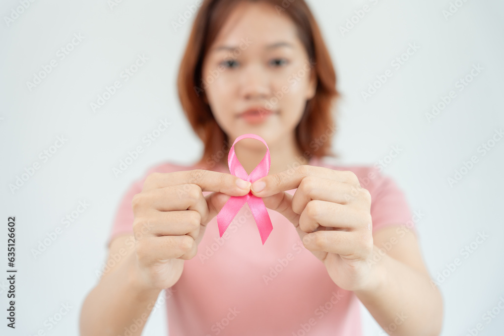 Woman hold pink ribbon breast cancer awareness. Female health check consciousness. international Women Day and World Cancer Day. sign cancer, Symbolic, health care, support patients, timely diagnosis Woman hold pink ribbon breast cancer awareness. Female health check consciousness. international Women Day and World Cancer Day. sign cancer, Symbolic, health care, support patients, timely diagnosis