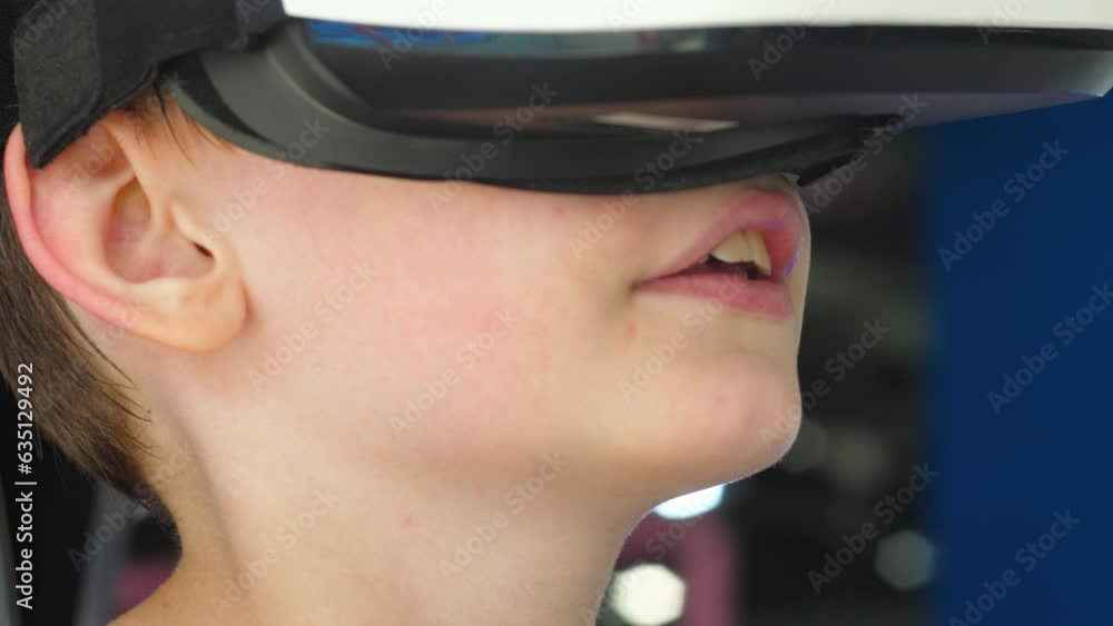 close-up caucasian boy in a helmet wearing virtual reality glasses on amusement rides in a children's park. modern entertainment for children virtual reality 3d close-up caucasian boy in a helmet wearing virtual reality glasses on amusement rides in a children's park. modern entertainment for children virtual reality 3d