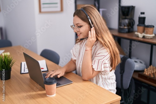 Young blonde woman call center agent smiling confident working at office